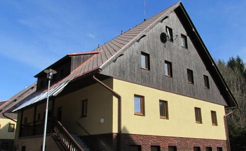a large house with a gambrel roof on top of it at Apartmán Cardovi in Dolní Morava