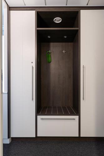 a locker room with white cabinets and a green bag at Hotel Molenzicht in Nes