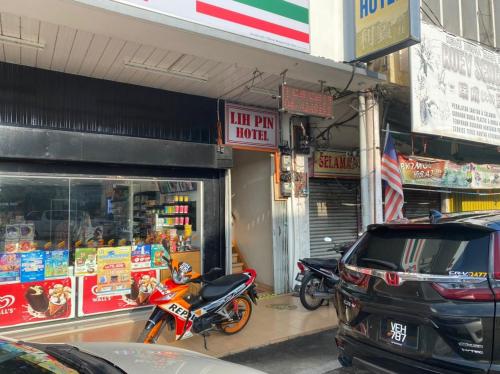 sklep z dwoma motocyklami zaparkowanymi przed nim w obiekcie Lih Pin Hotel w mieście Sungai Petani