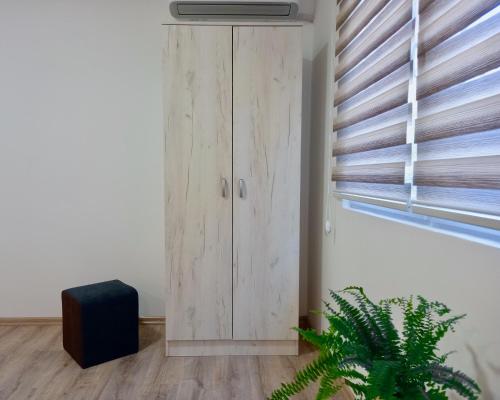 a wooden cabinet in a room with a window at Apartmani Lorić in Višegrad
