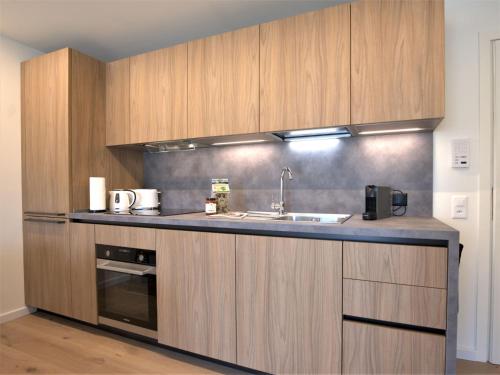 a kitchen with wooden cabinets and a sink at Apartment Chesa Stè by Interhome in Celerina