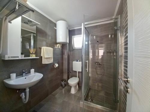 a bathroom with a shower and a sink and a toilet at Apartmani Lorić in Višegrad