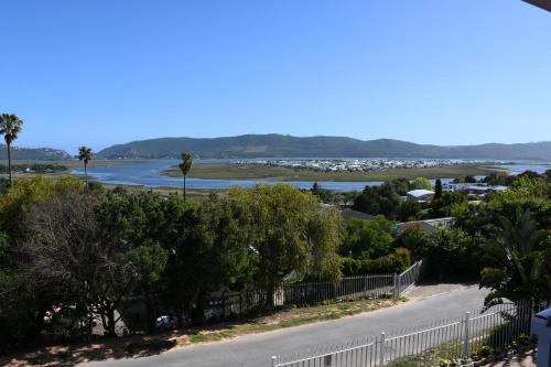 a road with a view of the ocean and a beach at Friendz Guesthouse in Knysna