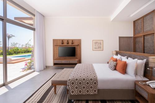 a hotel room with a bed and a television at Steigenberger Resort Ras Soma in Hurghada