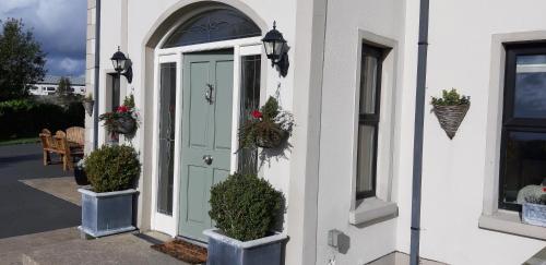 a front door of a house with potted plants at Safe Haven - Luxury Family Accommodation in Carlingford