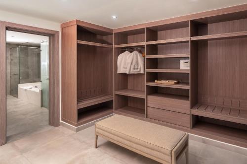 a walk in closet with wooden shelves and a bench at Steigenberger Resort Ras Soma in Hurghada