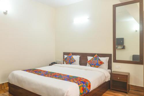 a bedroom with a large bed with a large mirror at FabHotel Kutighar Regency in Gangtok