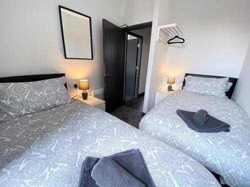 a bedroom with two beds and a hat on the bed at StayCrewe Apartments in Crewe
