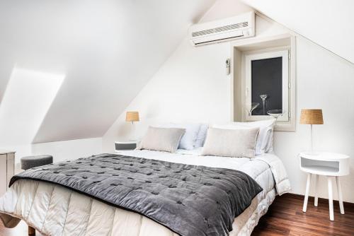 een witte slaapkamer met een groot bed en een raam bij GITE DE L'ORME in Sancerre