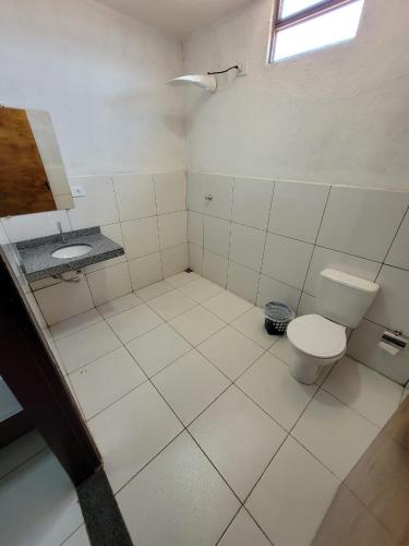 a bathroom with a toilet and a sink at Hotel Buriti in Carolina