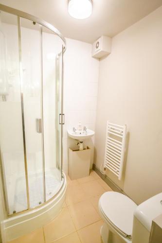 a bathroom with a shower and a toilet and a sink at Townhouse No 12 in Huddersfield
