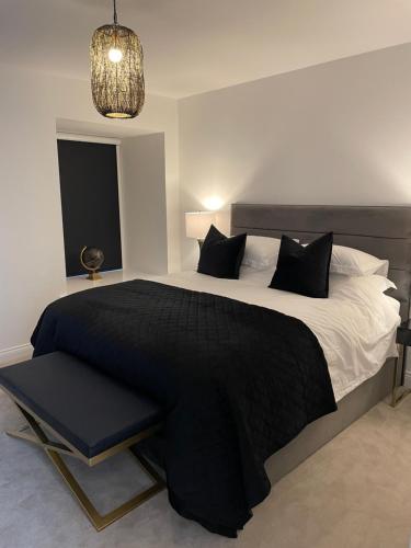 ein Schlafzimmer mit einem großen Bett mit einer schwarzen Decke in der Unterkunft The Bronte Bobbin in Haworth
