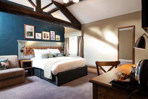 a bedroom with a bed and a desk and a chair at The Castle by Innkeeper's Collection in Castleton