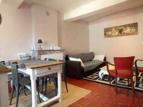 un salon avec un canapé, une table et des chaises dans l'établissement La Maison MOJA, à Préty