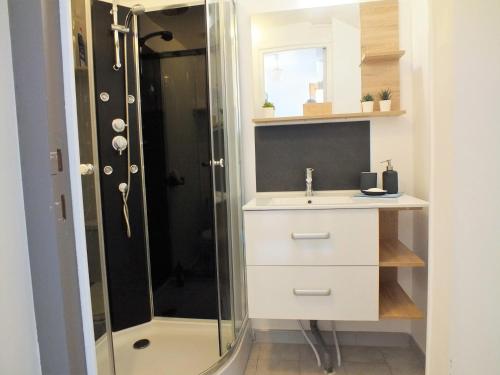 a bathroom with a sink and a shower at La Maison MOJA in Préty