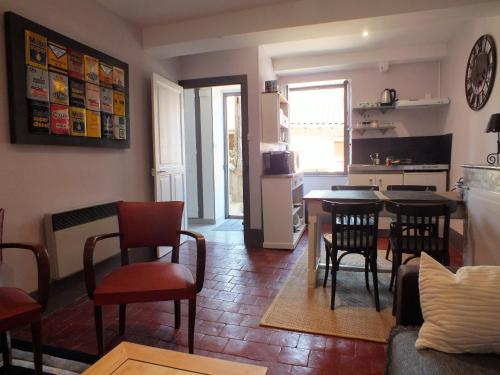 a kitchen and living room with a table and chairs at La Maison MOJA in Préty