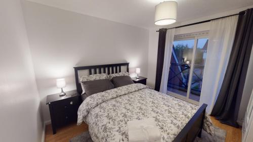 a bedroom with a bed and a large window at JEGS Estate in Thamesmead