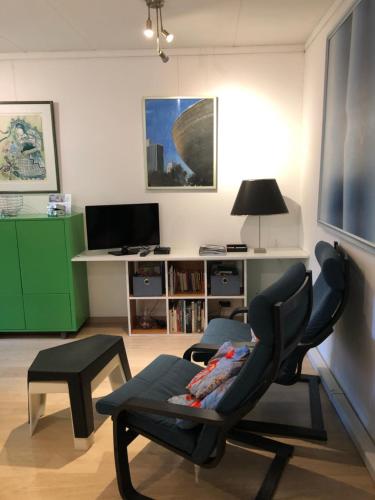 a living room with a chair and a desk at Linden-Jachthoorn in Lubbeek