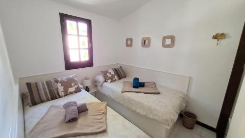 Pokój z 2 łóżkami z ręcznikami i oknem w obiekcie Casa EL JARDIN w mieście Morro del Jable