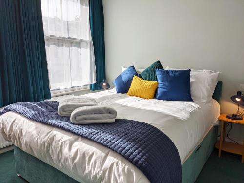 a bed with towels on it in a room with a window at The Stirling Arms Pub & Rooms in Brighton & Hove