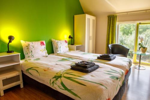 1 dormitorio con 1 cama grande y pared verde en Het Groene Wout, en Goudriaan