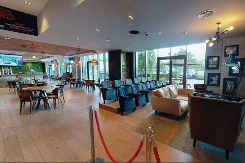 a restaurant with chairs and tables and a bar at Village Hotel Manchester Ashton in Ashton under Lyne