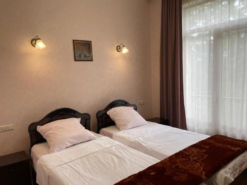 two beds sitting next to a window in a bedroom at Freedom Square Apartment in Tbilisi City