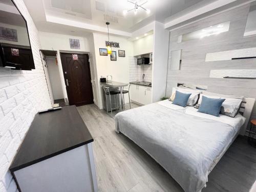 een slaapkamer met een groot bed en een keuken bij Apartment Studio New York 51 in Irpin'