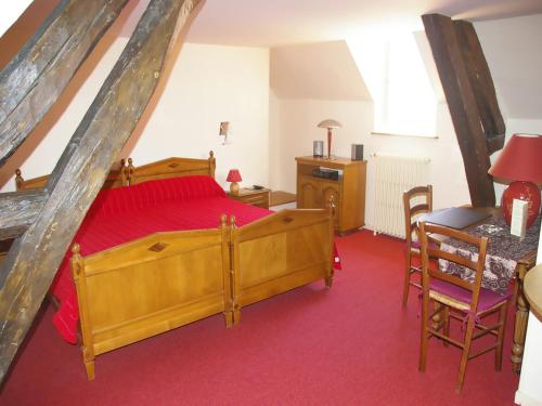 Schlafzimmer mit einem Holzbett, einem Tisch und Stühlen in der Unterkunft Hostellerie De La Poste in Clamecy