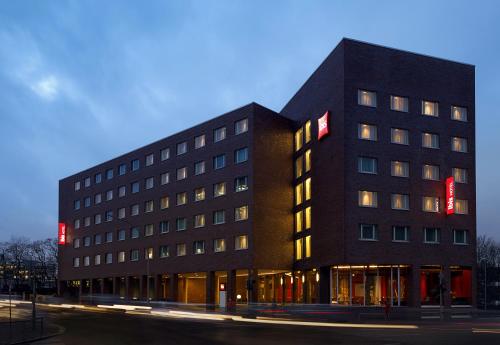 duży czarny budynek z czerwonymi znakami w obiekcie ibis Hamburg Alsterring w mieście Hamburg