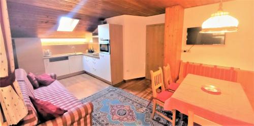 a living room with a couch and a table and a kitchen at Residence Carin in Selva di Val Gardena