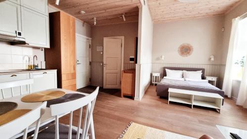 a bedroom with a bed and a table and a kitchen at Villa Frieda in Haapsalu