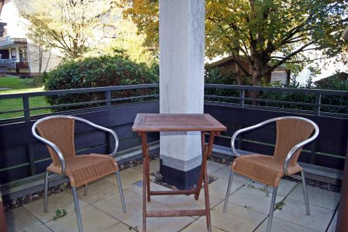 duas cadeiras e uma mesa num alpendre com uma coluna em Winterberg Appartement 21112 em Winterberg