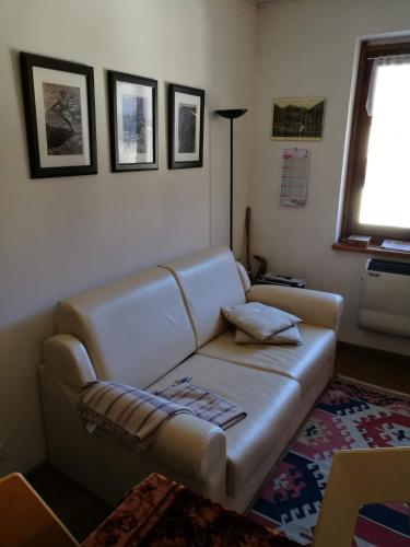 a living room with a leather couch and a window at Appartamento a Fraisse. Natura e sport. A pochi minuti da Pragelato in Usseaux