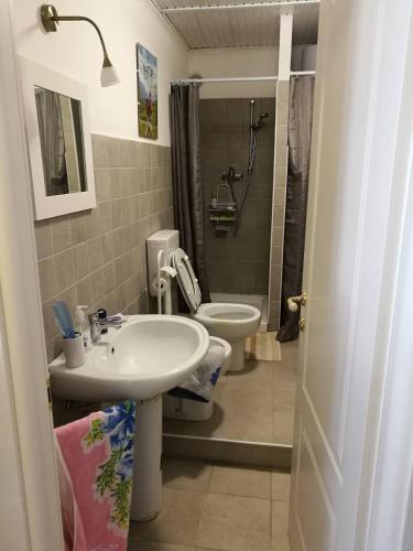a bathroom with a sink and a toilet and a shower at Appartamento a Fraisse. Natura e sport. A pochi minuti da Pragelato in Usseaux