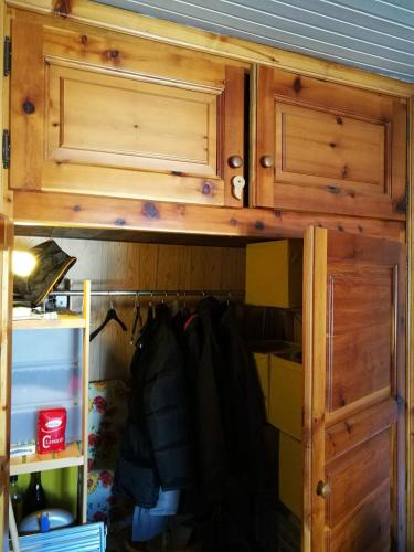 une armoire en bois avec des portes et un tiroir dans l'établissement Appartamento a Fraisse. Natura e sport. A pochi minuti da Pragelato, à Usseaux
