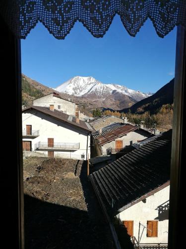 a view from a window of a town with snow covered mountains at Appartamento a Fraisse. Natura e sport. A pochi minuti da Pragelato in Usseaux