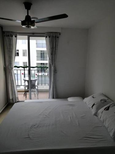 a white bedroom with a bed and a window at Apartamento vacacional amplio, cómodo y tranquilo. in Ricaurte