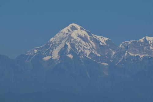 a mountain covered in snow on a clear day at Captains Paradise Luxury Resort at Mukteshwar Hill Station in Mukteswar