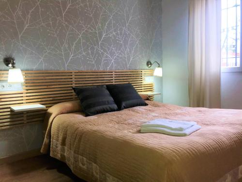 a bedroom with a bed with two towels on it at Apartamentos Rondaluz in Ronda
