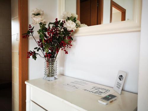 a vase of flowers on a counter in a bathroom at Apartamentos Rondaluz in Ronda