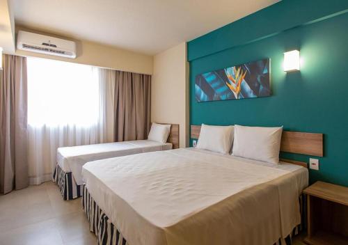 a hotel room with two beds and a blue wall at SOLAR DAS AGUAS PARQUE RESORT in Olímpia