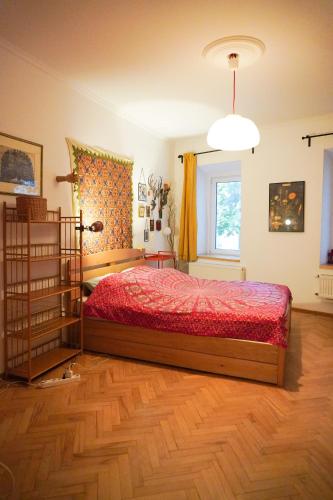 una camera da letto con un letto con un piumone rosso e una finestra di chio's place a Tbilisi City