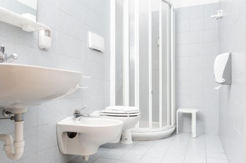 a white bathroom with a toilet and a sink at Villaggio Torre Marina in Marina di Massa