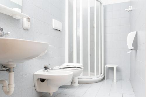 a white bathroom with a toilet and a sink at Villaggio Torre Marina in Marina di Massa
