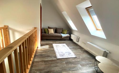 a living room with a couch and a staircase at PRIMA Inn Ferienwohnungen Sonnenufer am Ruppiner See in Neuruppin