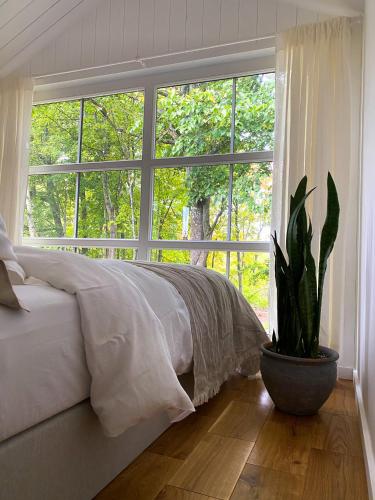 a bedroom with a bed and a large window at Ragnar Glamp Koknese in Koknese