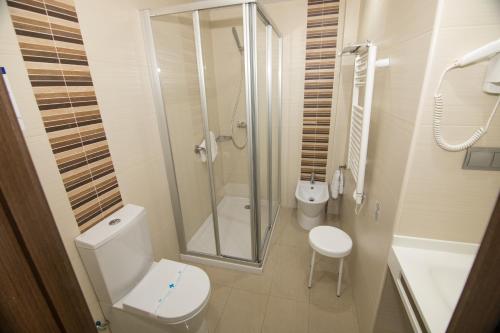 a white bathroom with a toilet and a shower at Hotel Porto Calpe in Calpe