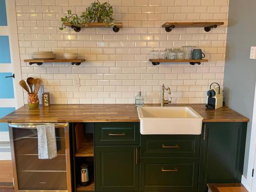 a kitchen with green cabinets and a sink at Les Chambres Roses in West Kelowna