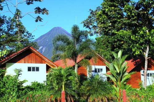 a house with a mountain in the background at Selvita Lodge Arenal in Fortuna